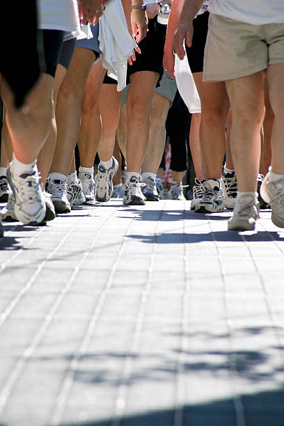 Walkers crowd of walkers in a charity walk-a-thon. walking for a cause stock pictures, royalty-free photos & images