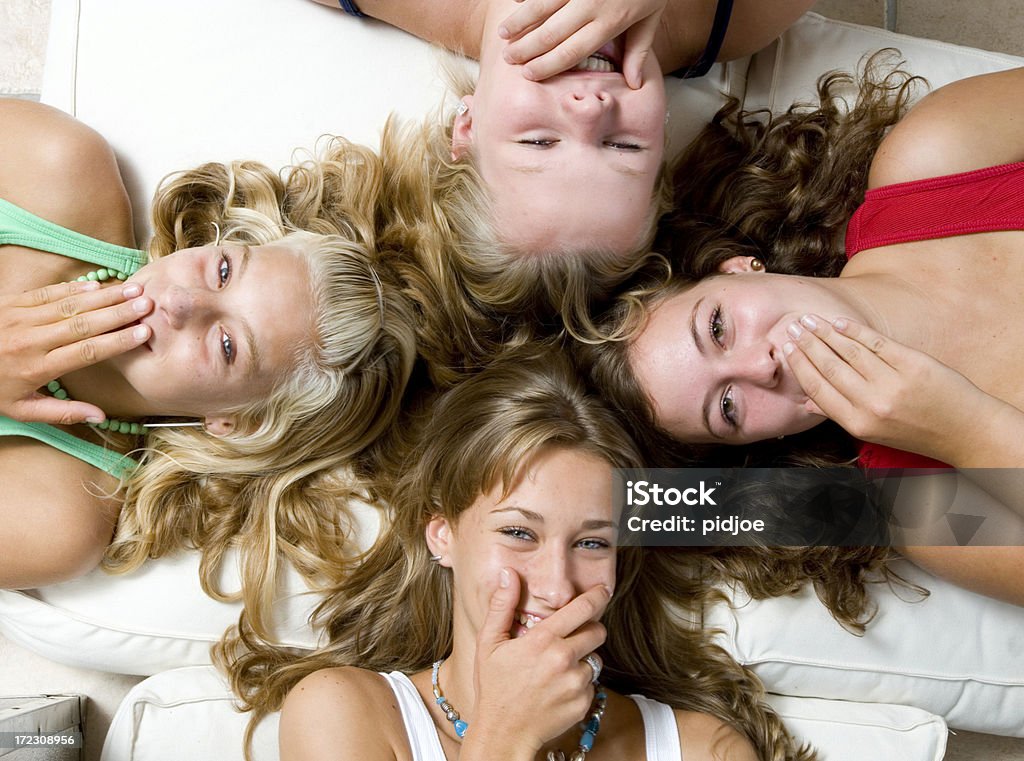 Quattro ragazze sdraiato Risatina - Foto stock royalty-free di Sdraiato