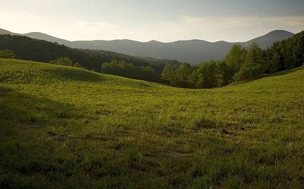 "Green field in country side with beautiful appalachian mountain in the background. Shot in Dalonegah, Georgia."