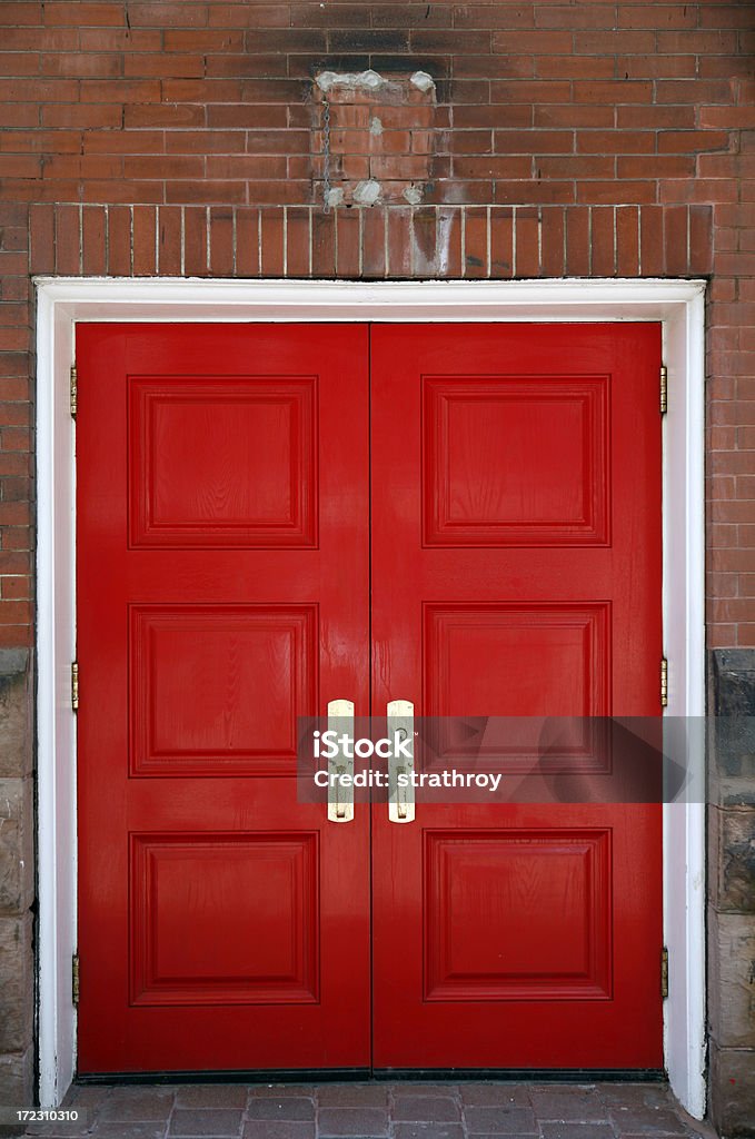 Rouge deux poignées de porte en laiton et blanc encadrent - Photo de Symétrie libre de droits