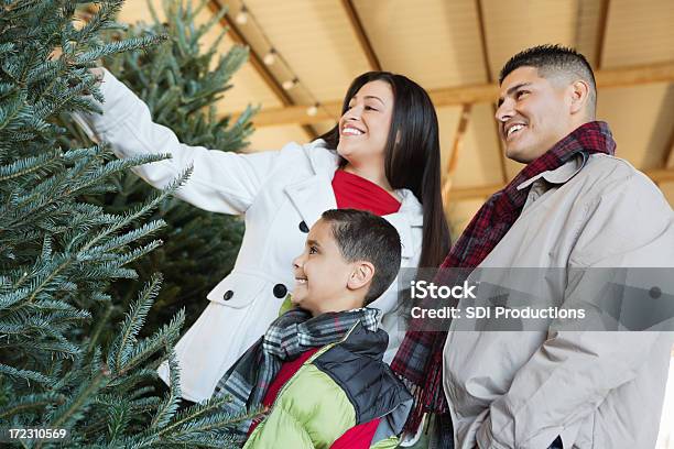 Felice Famiglia Ispanica Scelta Di Albero Di Natale Di Acquisto - Fotografie stock e altre immagini di Negozio di alberi di Natale