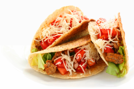 Tacos isolated on white.  Focus on the tomatoes in the rightmost taco.  See also: