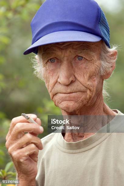 Idosos O Homem Fumar - Fotografias de stock e mais imagens de Adulto - Adulto, Ao Ar Livre, Boné