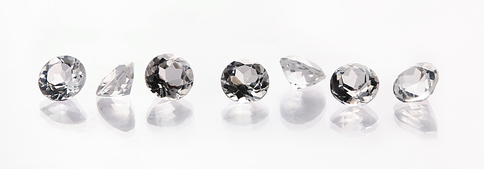 Loose diamonds on a reflective surface. (stones are white topaz)