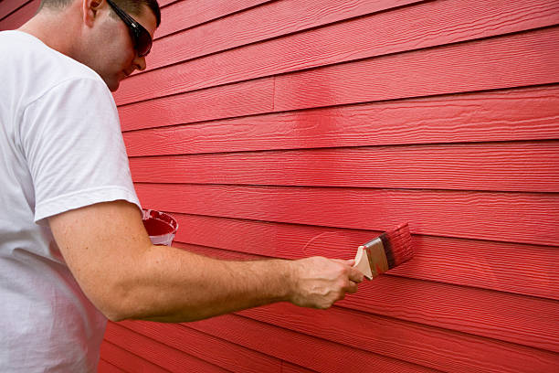 istock Man painting wood exterior with red paint 172311274