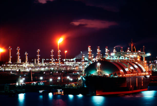 Oil Industry. LNG (Liquid Natural Gas) tanker at port with LNG liquefaction plant in background. LNG Liquefaction Equipment stock pictures, royalty-free photos & images