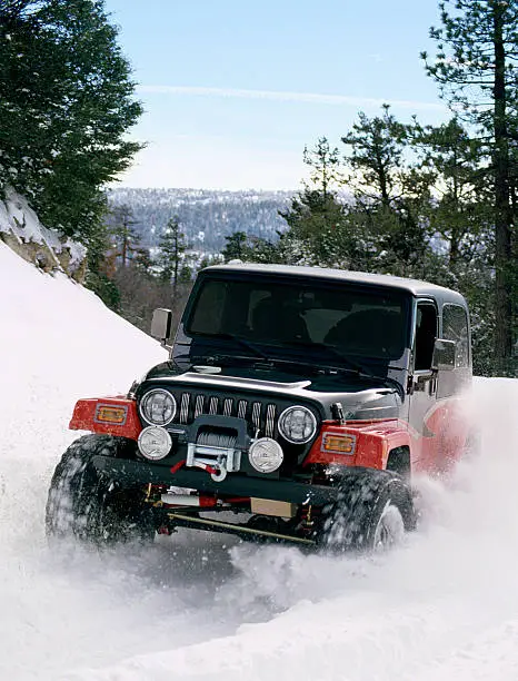 A four wheel drive vehicle playing in the snow