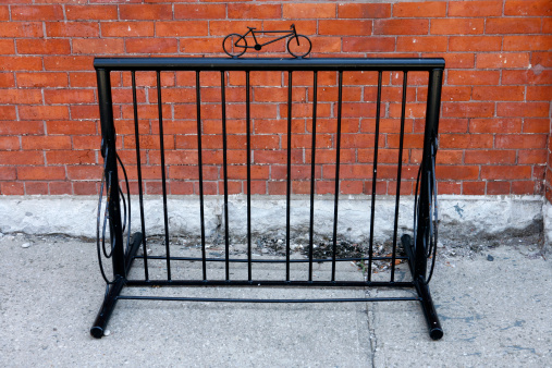 Antique bicycle stand in front of a brick wall