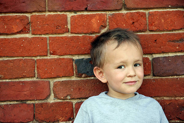 istock boy on  background of brick wall 172313967