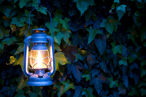 Wall-mounted outdoor lamp illuminated by a narrow beam of light.
