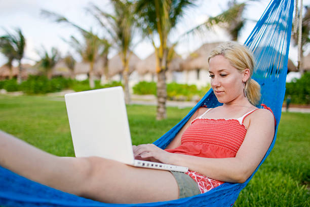 istock Blond Young Woman Using Laptop on Tropical Hammock, Copy Space 172314936