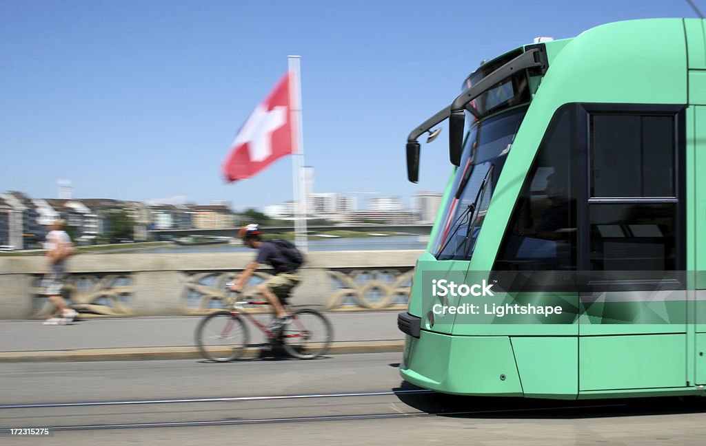 Basel City / Street Car Modern Street Car in Basel, Switzerland, with motion blur. In the background you can see the Swiss National Flag and the Rhine River. Switzerland Stock Photo