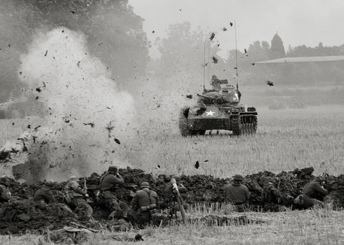 World War Two. The nazi army coming under fire from an American tank. Subtle sepia toning. Noise added to enhance the mood. Shot at a re-enactment event.