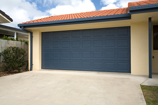 A blue double garage door on a brand new home.