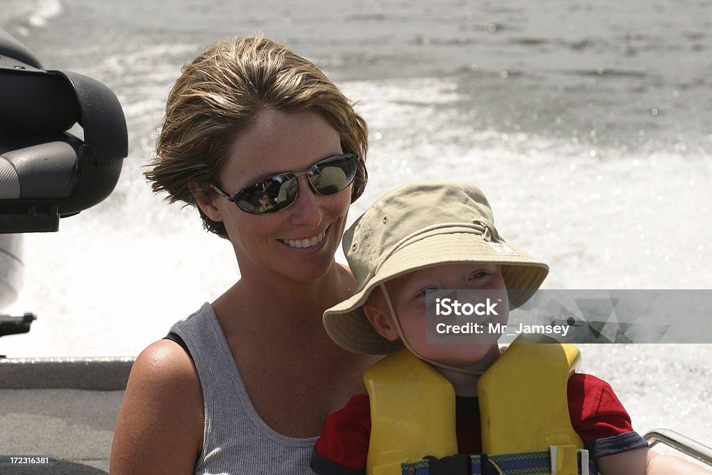 Boating Mother and Son A young mother and her toddler son riding in a boat on a lake. Family Stock Photo