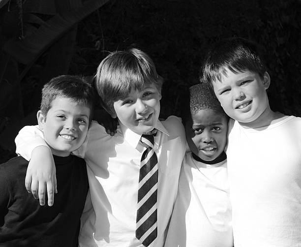Four schoolboy friends pose together in the late afternoon sunshine.
