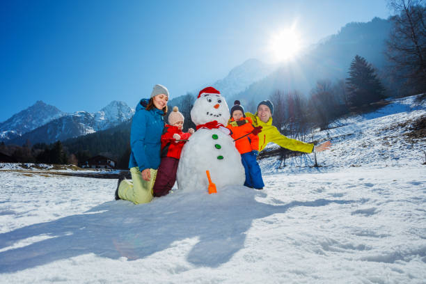 istock Dad with mom and three kids play building snowman 1723182553