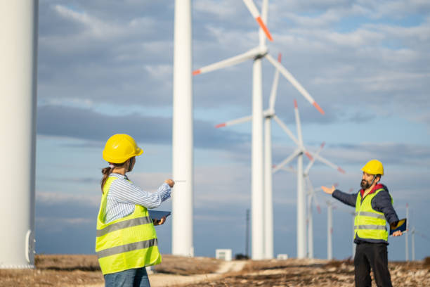 istock Pregnant wind energy engineer working in team at wind farm. 1723195831