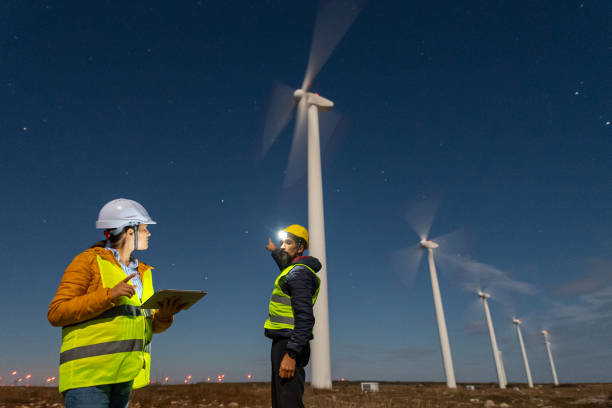 istock Pregnant wind engineer working in team at night in wind farm. 1723195853