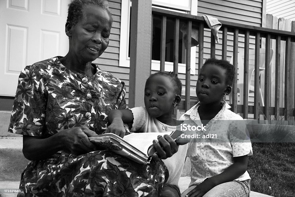 mentorship (b/w) African grandmother reading the Bible to her granddaughters Photography Stock Photo