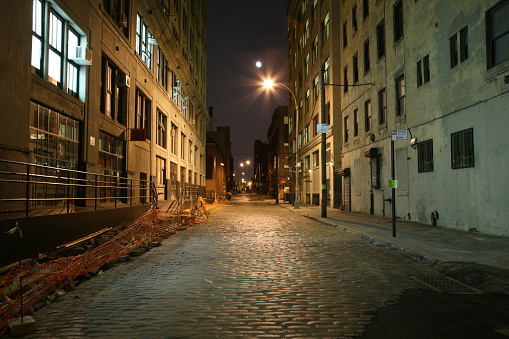The moon rises down a Brooklyn backstreet in the waterfront district of DUMBO.
