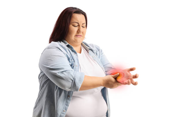 Corpulent young woman experiencing pain in hand wrist Corpulent young woman experiencing pain in hand wrist isolated on white background obese joint pain stock pictures, royalty-free photos & images