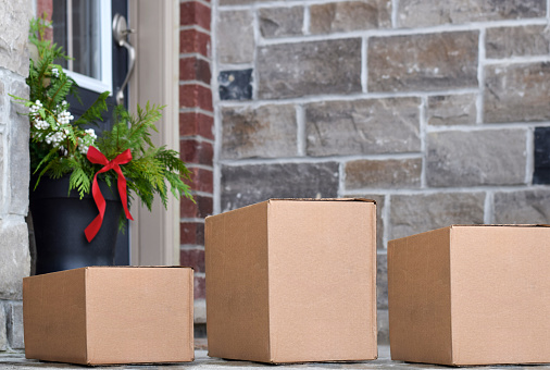 Three parcel boxes delivery on a front porch of a house during Christmas time