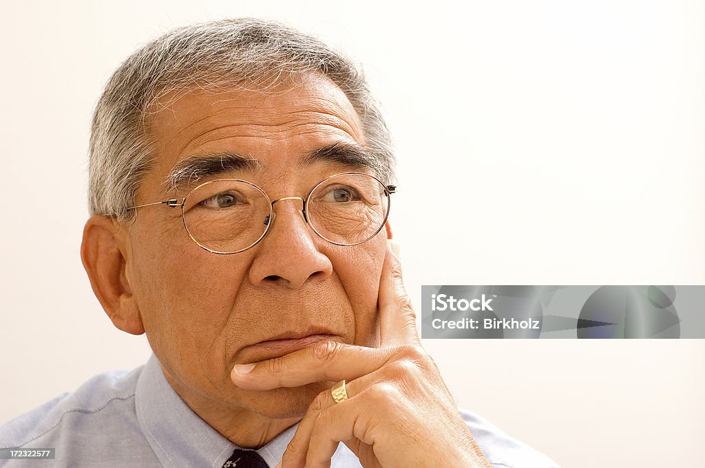 Asian Business Man Portrait of an Asian/Chinese businessman.  He's in thought, looking at a computer screen. (Small reflection of a computer screen in his eyes.) 60-69 Years Stock Photo