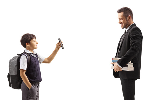 Schoolboy showing a smartphone to a male teacher isolated on white background