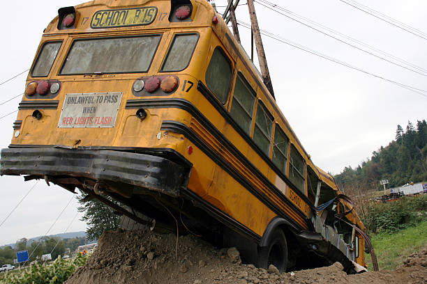 School bus wreck in ditch, rear passenger side view stock photo