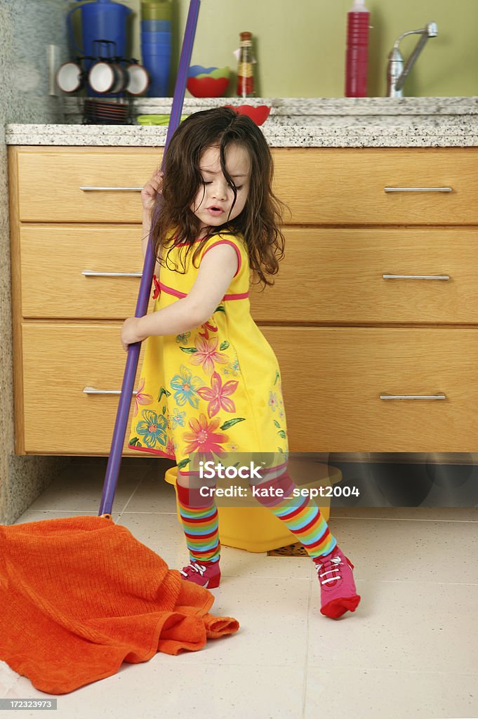 Petite fille nettoyage de la cuisine - Photo de Balai à franges libre de droits