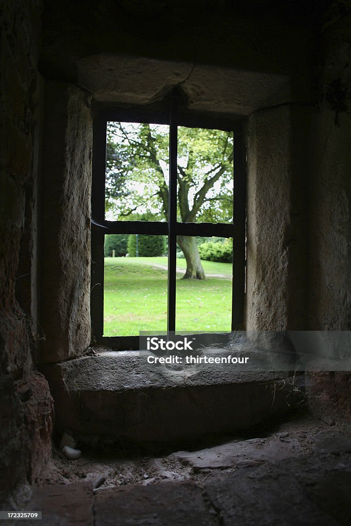It's nicer outside "View of grass and trees in Rufford Country Park from a small window in the dark undercroft of Rufford Abbey - a ruined Cistercian abbey in Nottinghamshire, England." England Stock Photo
