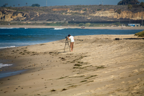 A man films surfers for a movie.