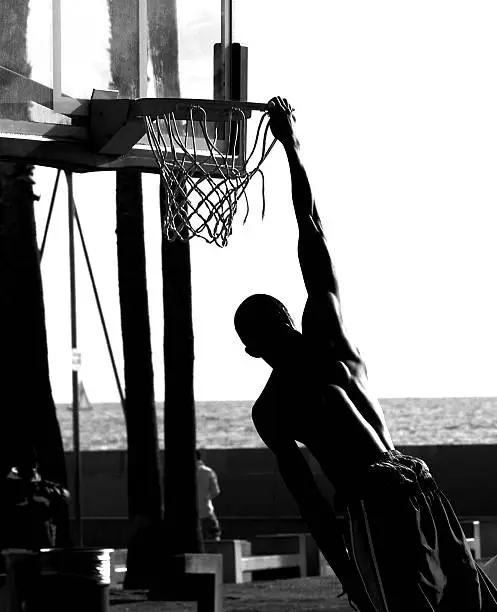man slam dunking a basketball on a court in Venice, California.