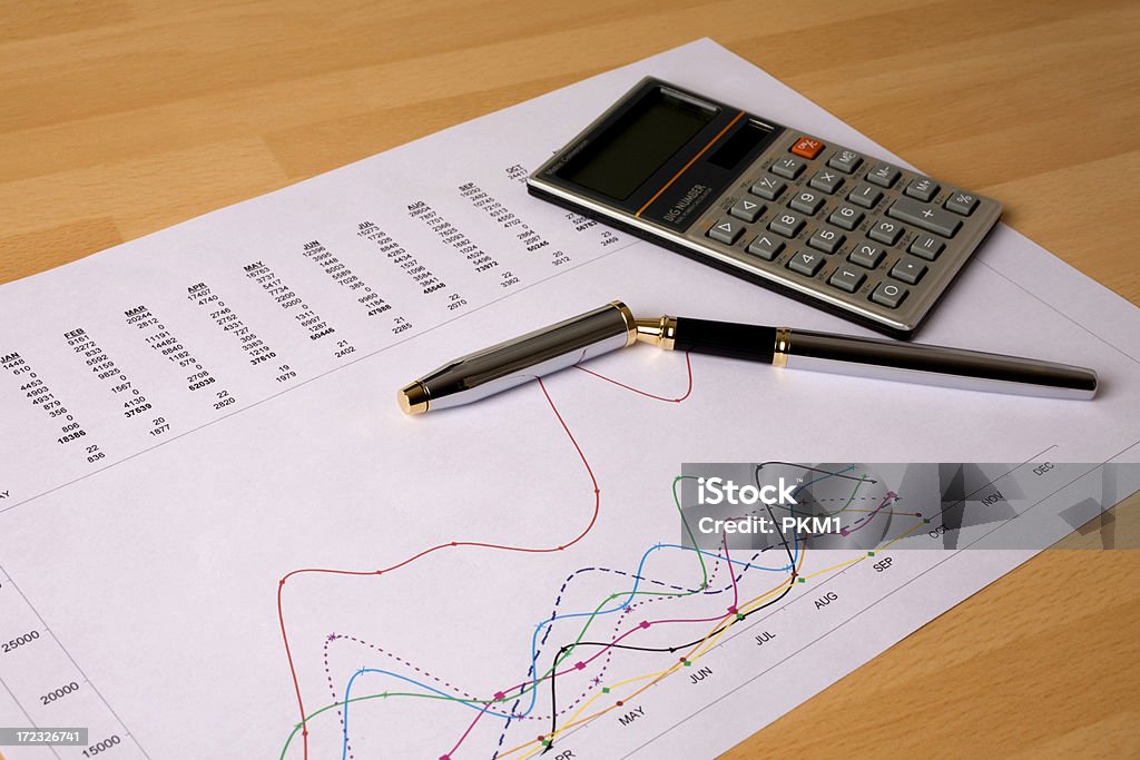 Financial Graph Calculator & pen on financial graph Analyzing Stock Photo