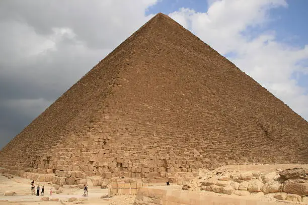 "The Great Pyramid of Giza, the only one of the Seven Ancient Wonders of the World still standing, towers over the tourists that awe in its splendor."