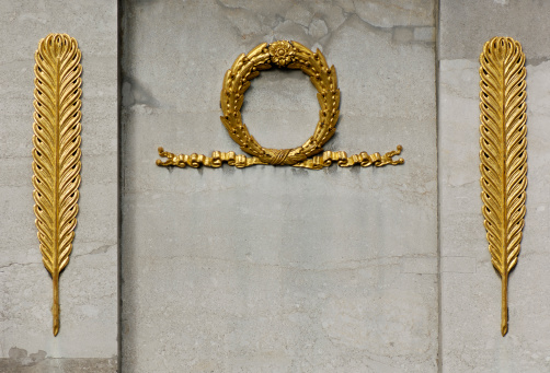 Decorative golden ornaments on a stone-base of a monument
