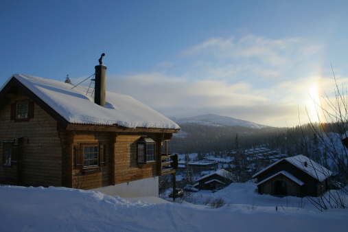 A traditional wooden ski chalet in the late afternoon sun.