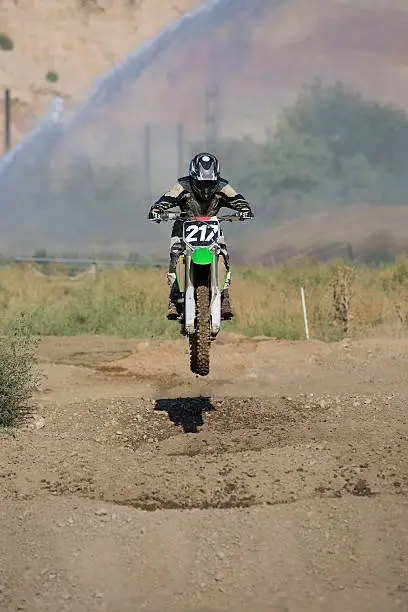 Motocross-rider flying over whoops section