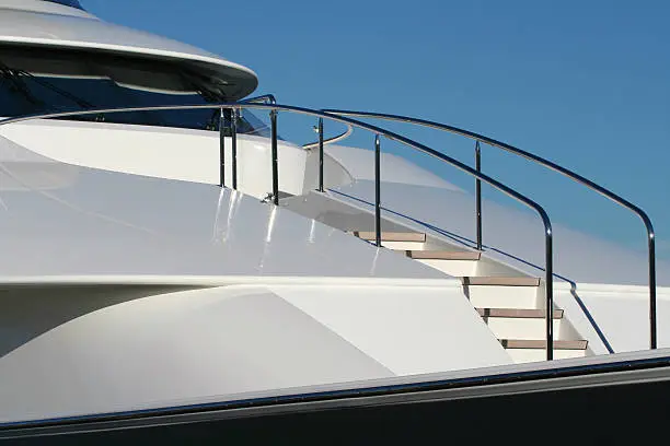 Closeup of foredeck with steps and railing on a luxury motor yacht, symbolizing success and wealth.