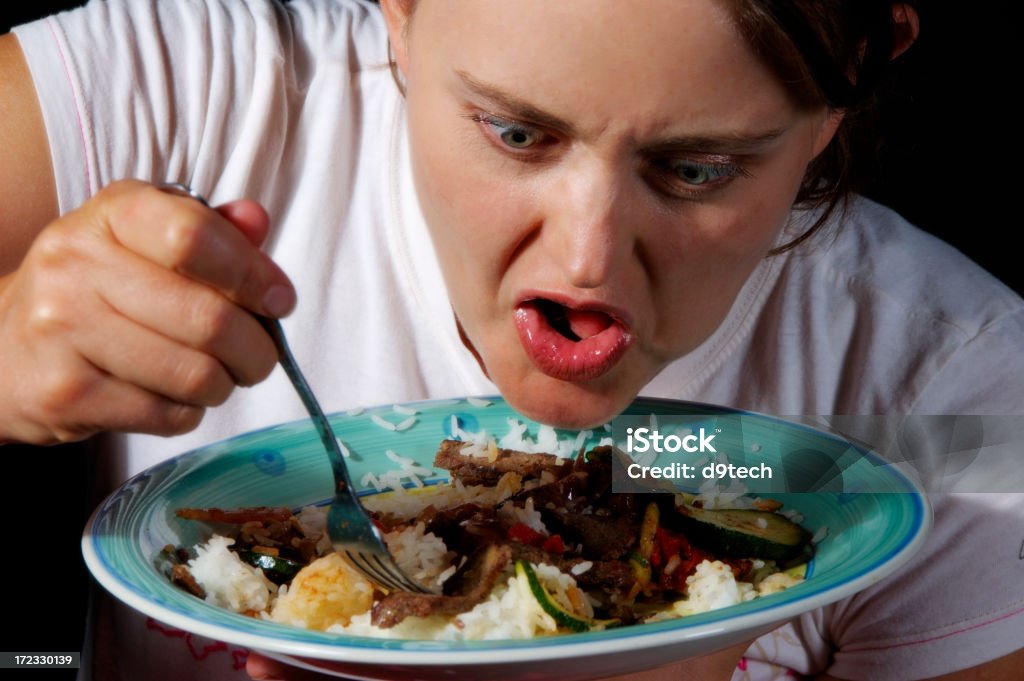 Very Hungry A very hungry woman digs in. Addiction Stock Photo