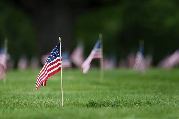 Memorial Day grave site flags. Focus on single flag on grave site of US serviceman. memorial day stock pictures, royalty-free photos & images