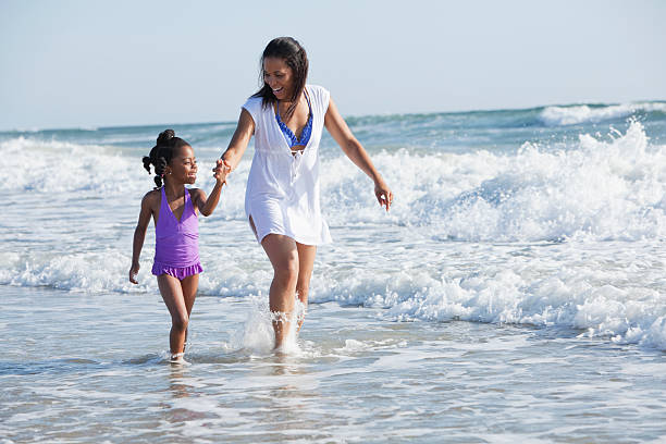 istock Mother and daughter walking in the surf 172331218