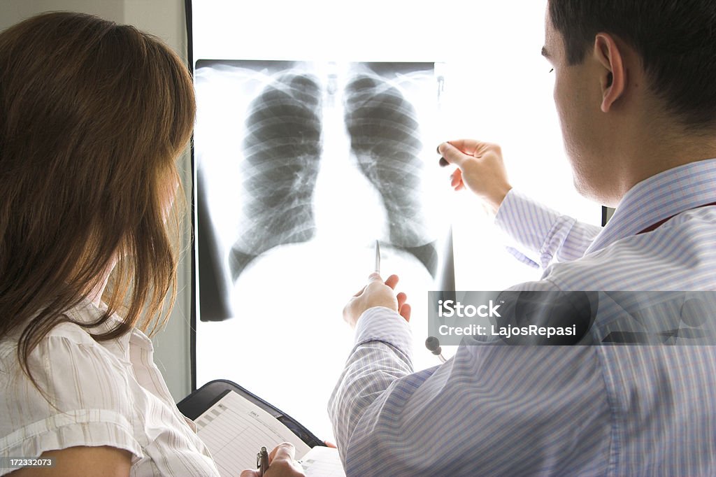 MÉDECINS consultation sur une X-ray - Photo de Adulte libre de droits