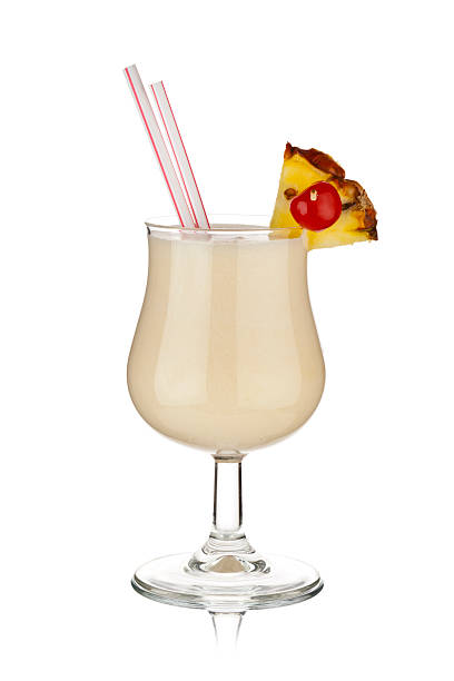 Pina colada tropical drink shot against white background Refreshing glass of piña colada cocktail shot on reflective white background. The glass is garnished with a pineapple slice and maraschino cherry. Two red and white drinking straws emerges from the drink. Visible reflection under the glass. DSRL studio photo taken with Canon EOS 5D Mk II fruit garnish stock pictures, royalty-free photos & images