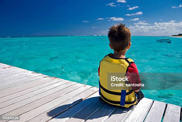 Photo libre de droit de Garçon Donnant Sur Le Lagon banque d'images et plus d'images libres de droit de Adolescent - Adolescent, Allée couverte de planches, Bleu