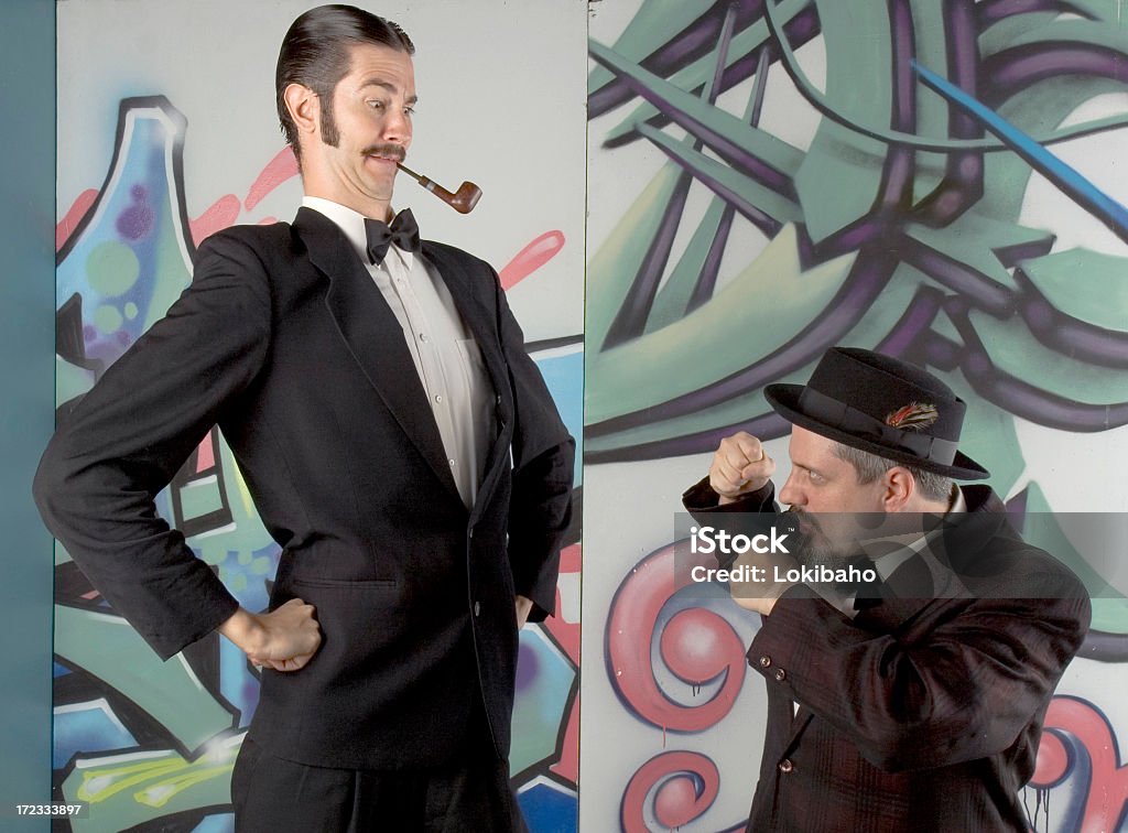 You're askin' for a Knuckle Sandwich! Very short man threatening a very tall man. Short Person Stock Photo