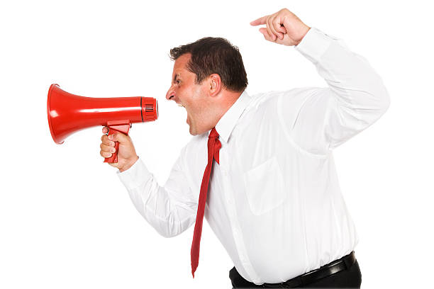 Anger Management Photo of a very angry businessman yelling into a red megaphone. cruel stock pictures, royalty-free photos & images