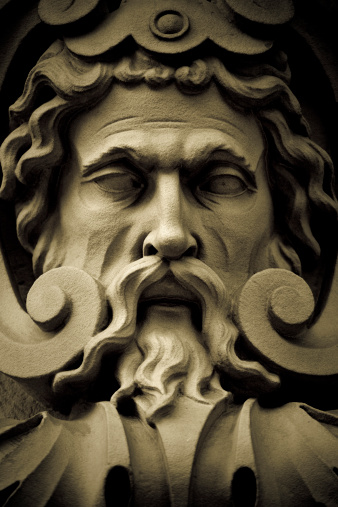 Detail of an old sculpture depicting a god.