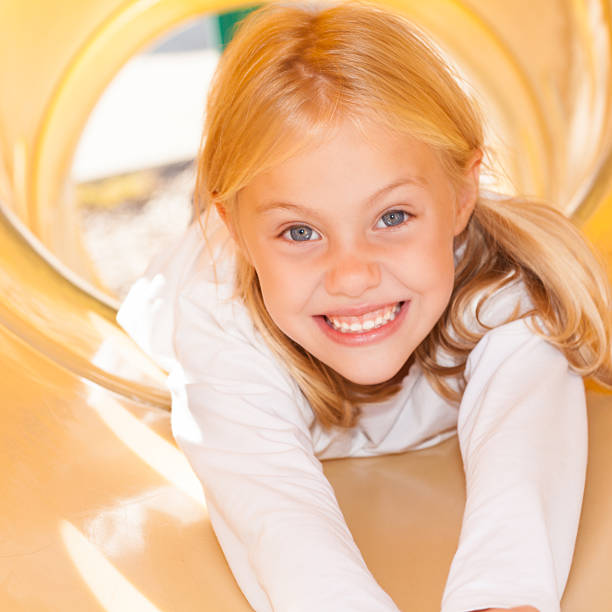 istock Cute elementary school girl on slide at recess 172336041